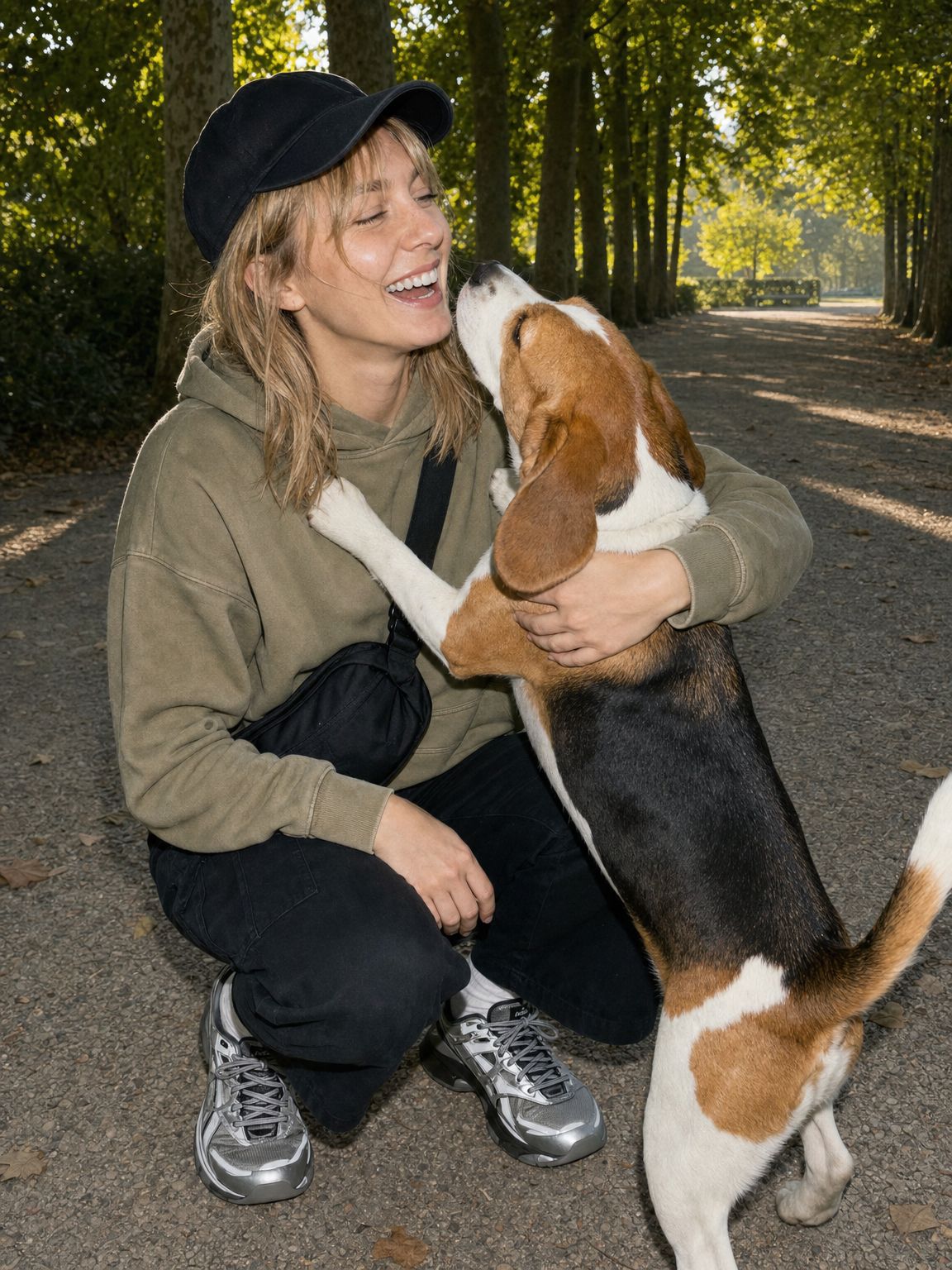 Une parente rit pendant que son beagle lui lèche le visage dans un parc.